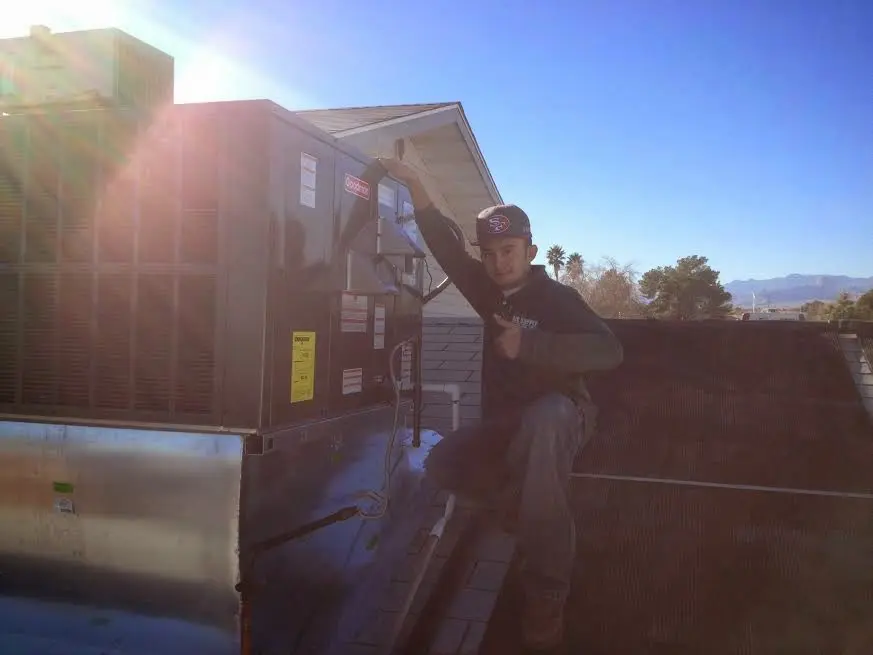 HVAC technician performing Heat Pump Repair on a rooftop unit in Hutto